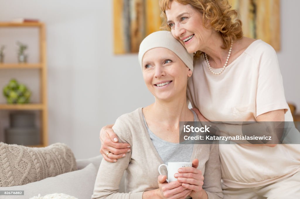 Struggling with illness Happy woman with scarf struggling with illness with her mom's help Cancer - Illness Stock Photo