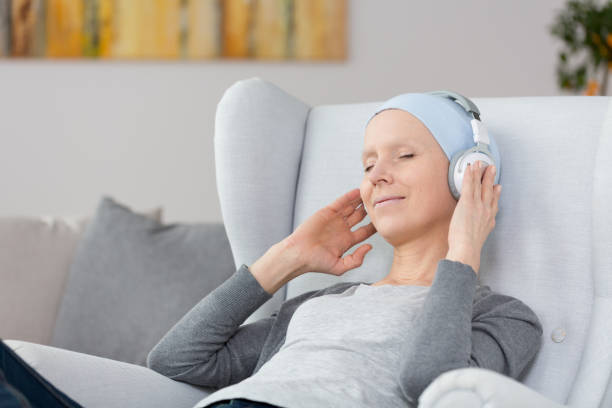 Music on headphones Woman with cancer listening to music on headphones at home human cardiopulmonary system audio stock pictures, royalty-free photos & images