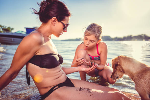 istock Mother, daughter and dog on the beach 826717190