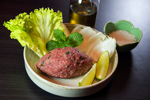 Raw kibbeh Lebanese food. Kibbeh nayeh. Traditional arabian food with onions, lime, lettuce and peppermint leaves.