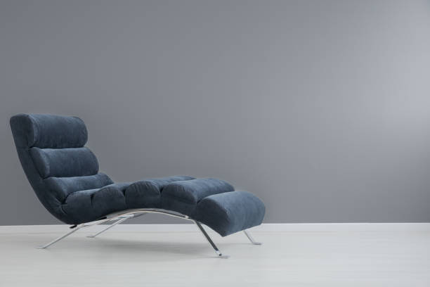 Navy blue chaise lounge Navy blue chaise lounge with metallic elements in spacious apartment chaise longue photos stock pictures, royalty-free photos & images
