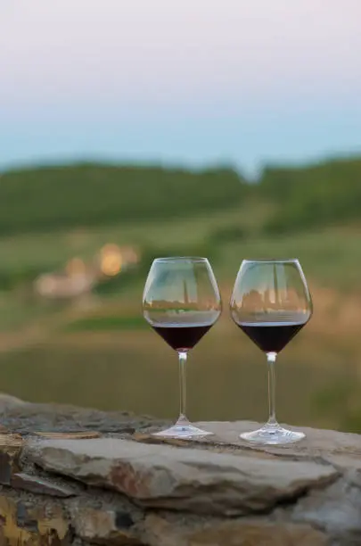 Red wineglasses at sunset on hillside at Radda in Chianti, Tuscany