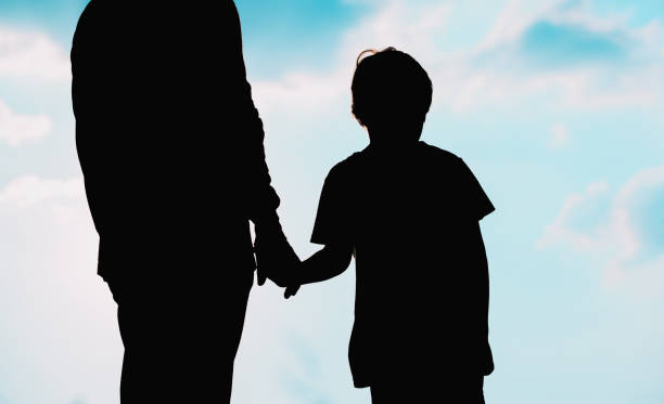 istock silhouette of father and son holding hands at sunset 826732340