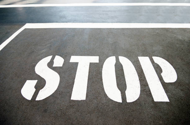 Stop sign painted on the asphalt.