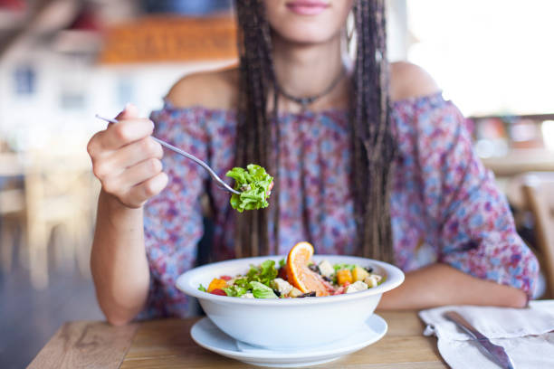 istock Unrecognizable young woman eating salad in restaurant 826744544