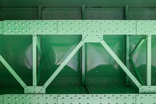 close up of green metal bridge structure for support trains