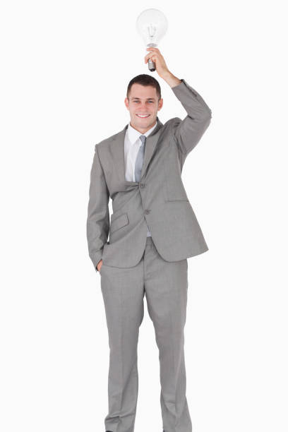 Portrait of a businessman holding a bulb above his head Portrait of a businessman holding a bulb above his head against a white background man with a light bulb over his head stock pictures, royalty-free photos & images