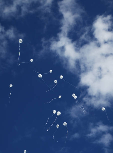 istock Balloons in blue sky, white clouds.  Vertical. 826753182