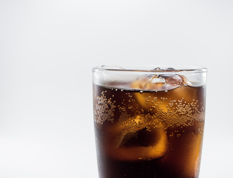 close up full soft drink is cool and ice cubes  in glass on white background