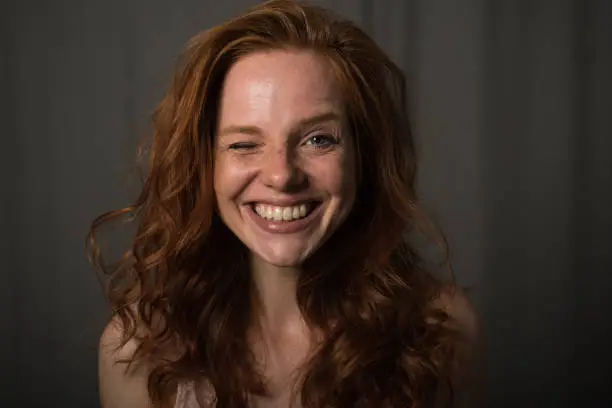 Young red-haired woman winking at the camera