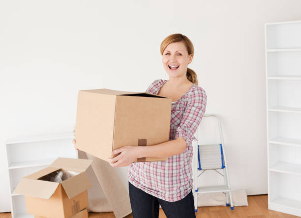 istock Smiling woman carrying cardboard boxes 826767006