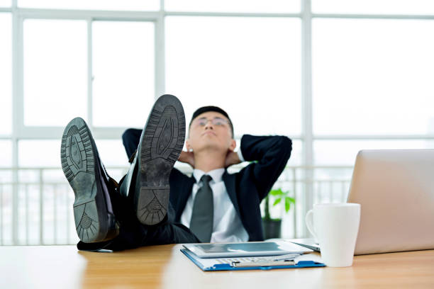 istock Businessman with feet up on desk 826767070