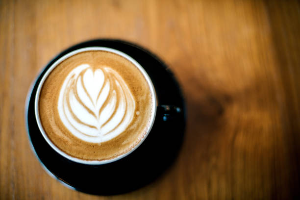 istock Latte art on dark grained wood top view 826767992