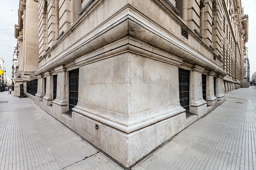 Ángulo de la esquina de un edificio de estilo neoclásico con dos banquetas photo