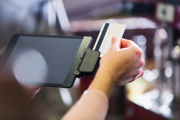 mano de mujer deslizando la tarjeta de crédito a través del lector - credit card reader fotografías e imágenes de stock