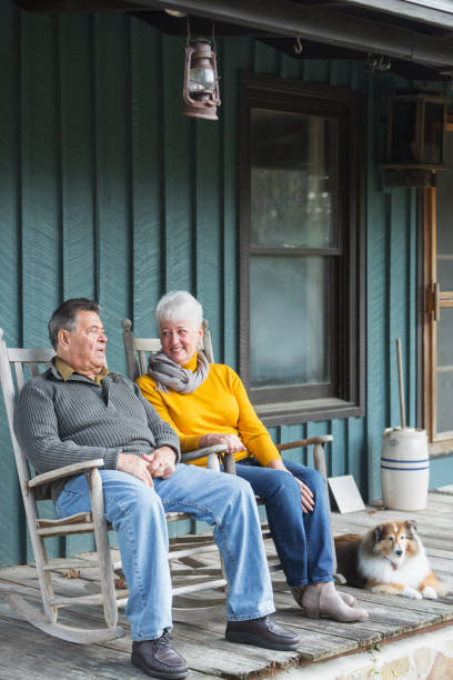 istock Senior couple talking on porch, smiling, with dog 826788526