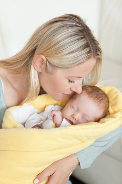 istock Affectionate mother kissing her sleeping baby in her arms 826789116