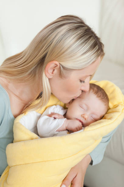 istock Affectionate mother kissing her newborns forehead 826789206
