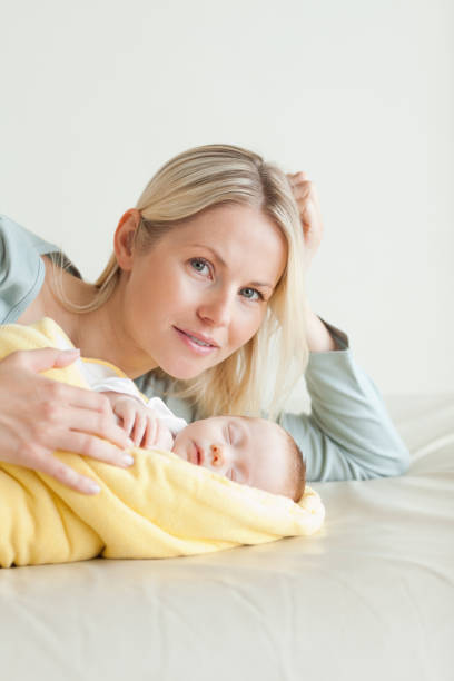 istock Mom lying next to her sleeping baby 826789284