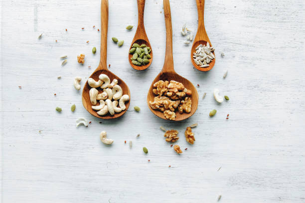 istock wooden spoons with seeds and nuts on the white table 826792718