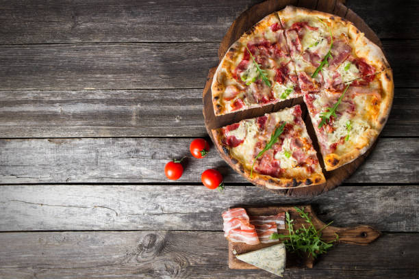 istock Pizza on the rustic wooden background with blank space 826793222
