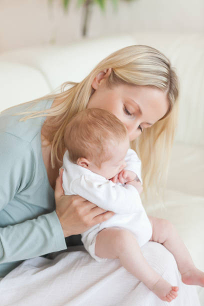 istock Mom on the sofa holding her baby 826793296