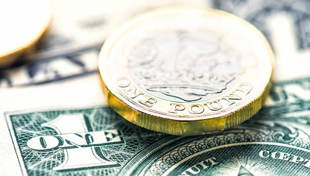 один доллар сша против одного британского фунта - one pound coin british currency coin paper currency стоковые фото и изображения