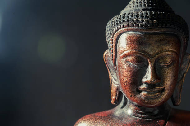 ภาพระยะใกล้ของพระพุทธรูปสีบรอนซ์ไม้บนพื้นหลังเบลอสีดํา - buddha face ภาพสต็อก ภาพถ่ายและรูปภาพปลอดค่าลิขสิทธิ์