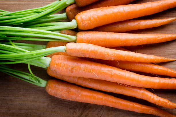 istock Fresh carrots on the wooden background. 826802756