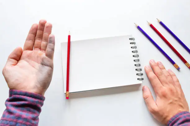 Photo of Left-handed man shows a dirty hand after writing mockup