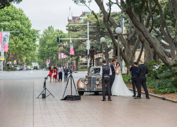 Bride and Groom at Hyde Park Sydney,NSW,Australia-November 19,2016: Bride, groom and wedding party with photographer and vintage car at Hyde Park in Sydney, Australia. hyde park sydney stock pictures, royalty-free photos & images