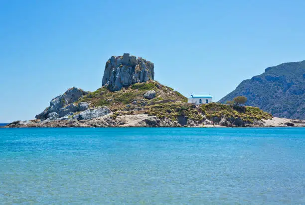 Small isle Kastri with white typical greek church, near Kefalos village in Kos island Greece.