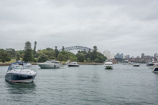 Sydney,NSW,Australia-November 19,2016: Nautical vessels in farm cove with view of Sydney Opera House and Sydney Harbour Bridge in Sydney, Australia.