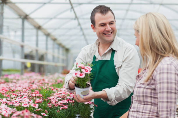 istock Woman deciding on flower with employee 826812876
