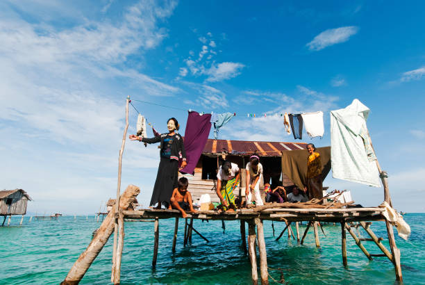 Bajau Laut Family Semporna , Malaysia: September 17, 2011: A family of Bajau Laut in their house balcony at the stilted village in Tun Sakaran Marine Park. mabul island stock pictures, royalty-free photos & images