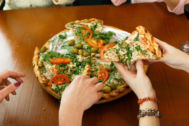 istock Group of young friends eating pizza in kitchen. 826820712