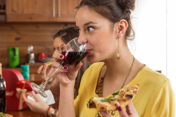 istock Beautiful young woman drinking red wine with friends 826821014