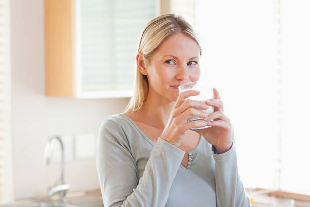 istock Woman standing in the kitchen drinking some water 826826168