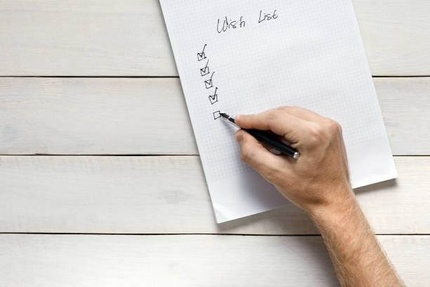 Person Filling Out Wish List, Top View. Memo Planning Strategy Process Ideas Concept stock photo