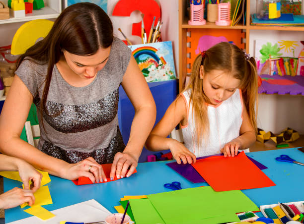 istock School children with scissors in kids hands cutting paper . 826843692