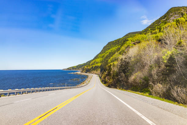 Coast of Gaspesie region of Quebec, Canada with road, cliffs and Saint Lawrence river ocean Coast of Gaspesie region of Quebec, Canada with road, cliffs and Saint Lawrence river ocean gaspe peninsula stock pictures, royalty-free photos & images