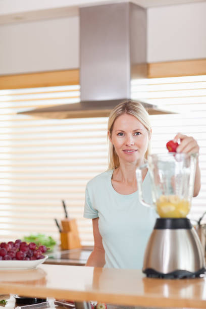 istock Woman putting strawberry into the blender 826854654