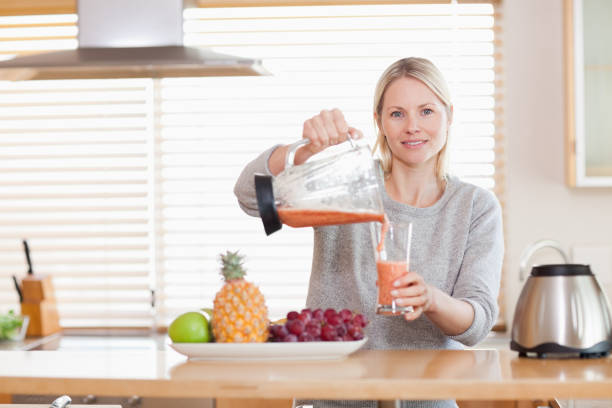 istock Woman pouring smoothie into a glass 826854734