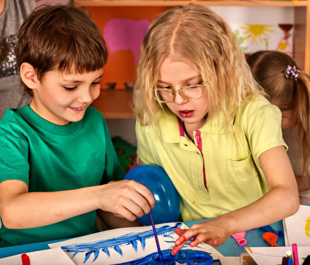 istock Small students children painting in art school class. 826860040