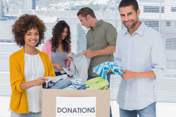 istock Team of volunteers taking out clothes from a donation box 826867976