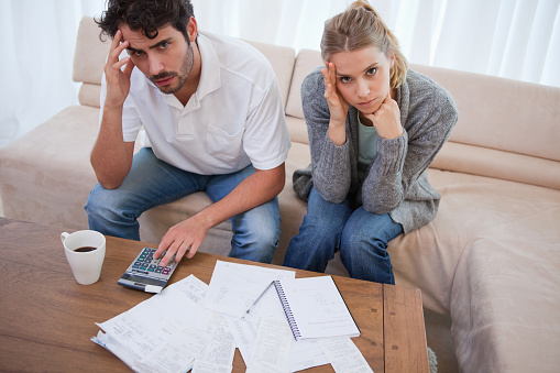 Worried couple doing their accounting in their living room