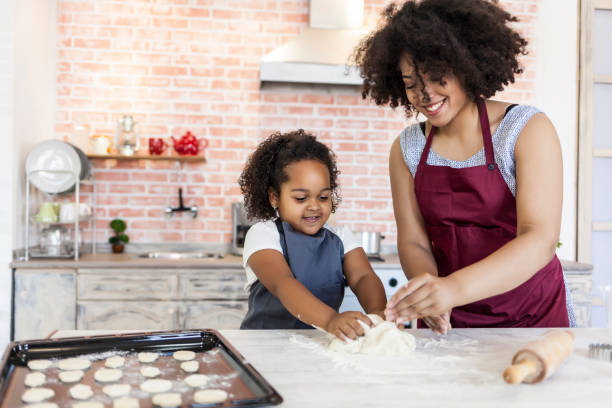 istock Mother and daughter preparing dough for homemade biscuits 826888436