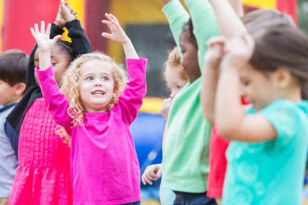 istock Multi-ethnic children playing in park, by bounce house 826906868