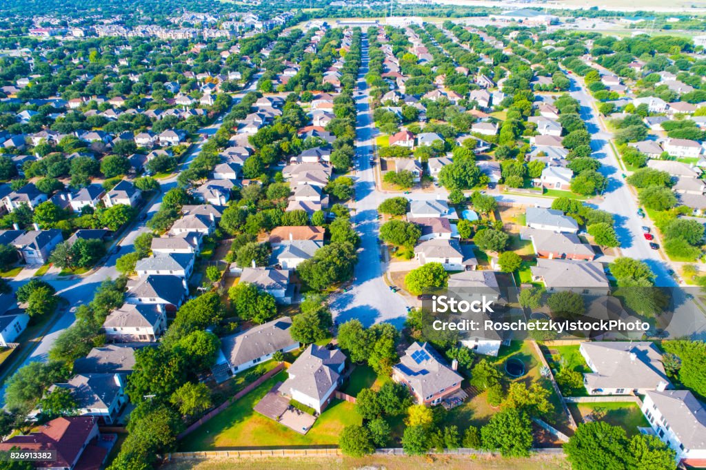 Aerial View of Large Suburb Entire View repeated homes and perfect rows of Houses and rooftops looking down on Neighborhood in North Austin near Wells Branch Aerial View of Large Suburb repeated homes and perfect rows of Houses and rooftops looking down on Neighborhood in North Austin near Wells Branch during a great Texas Summer lots of Green at morning right after sunrise Aerial View Stock Photo