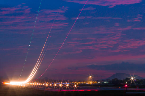 istock Light trails at airport runway, Against cloudy blue sky at dusk. 826917012